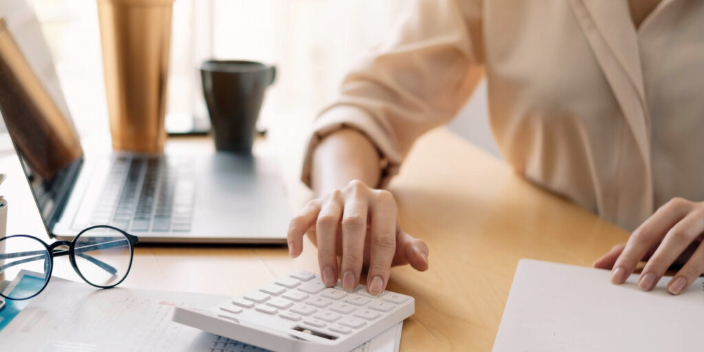 Profissional de RH organizando comprovantes sobre a mesa com um cartão MultiCorp ao lado, representando o reembolso para trabalhadores CLT com controle e agilidade.