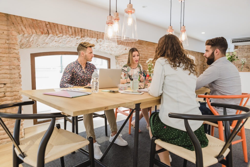 Escritório moderno com profissionais colaborando, demonstrando um ambiente agradável e produtivo no trabalho presencial.
