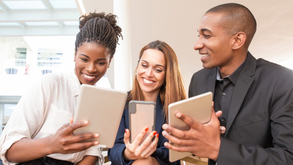 Equipe de colaboradores felizes escolhendo benefícios personalizados em uma plataforma digital.