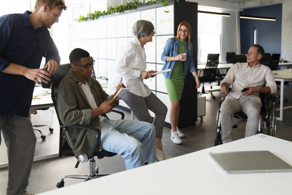 Colaboradores de diferentes idades reunidos em um ambiente corporativo, analisando opções de benefícios personalizáveis.