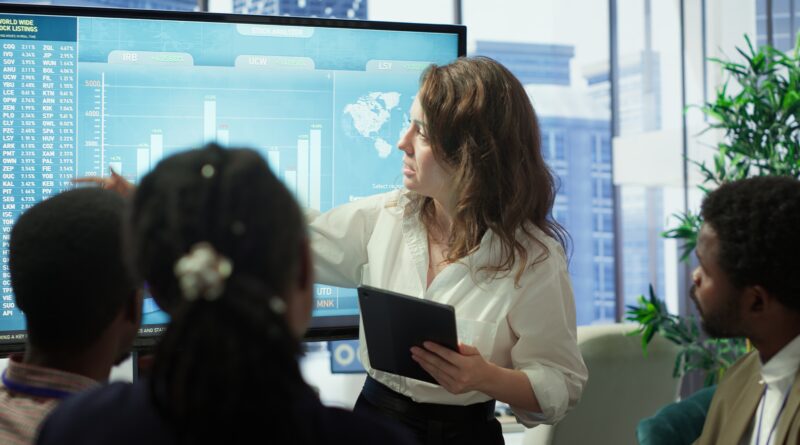 Equipe executiva reunida analisando dados financeiros em uma sala de reunião moderna, representando controle de gastos corporativos com decisão estratégica e colaboração.