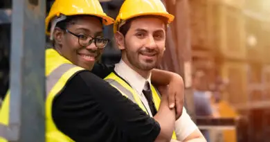 Riscos Psicossociais NR-1: trabalhadores da ind&uacute;stria usando capacete e colete de seguran&ccedil;a em ambiente operacional, representando bem-estar, colabora&ccedil;&atilde;o e cuidado no trabalho.